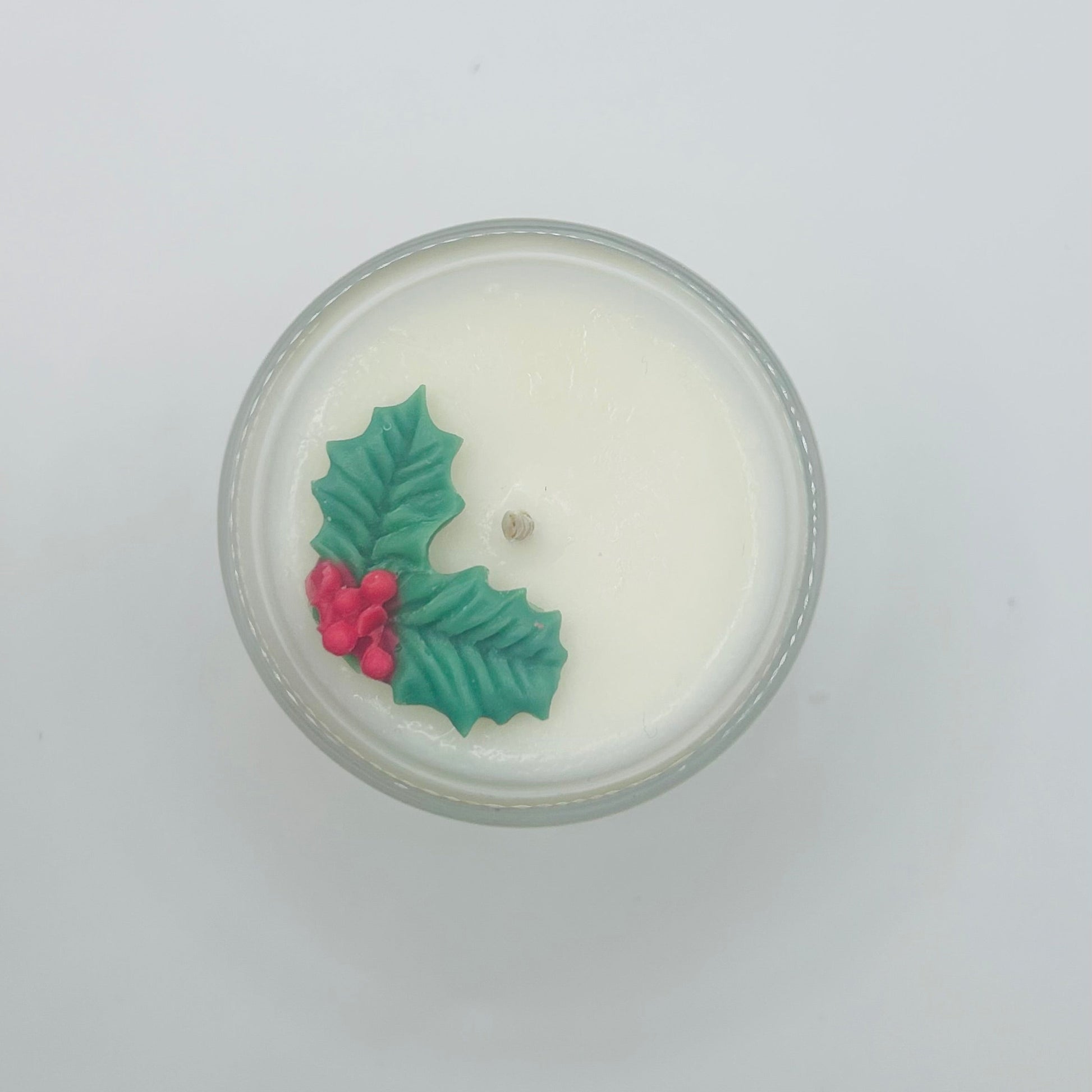 Candle with holly design on a white background