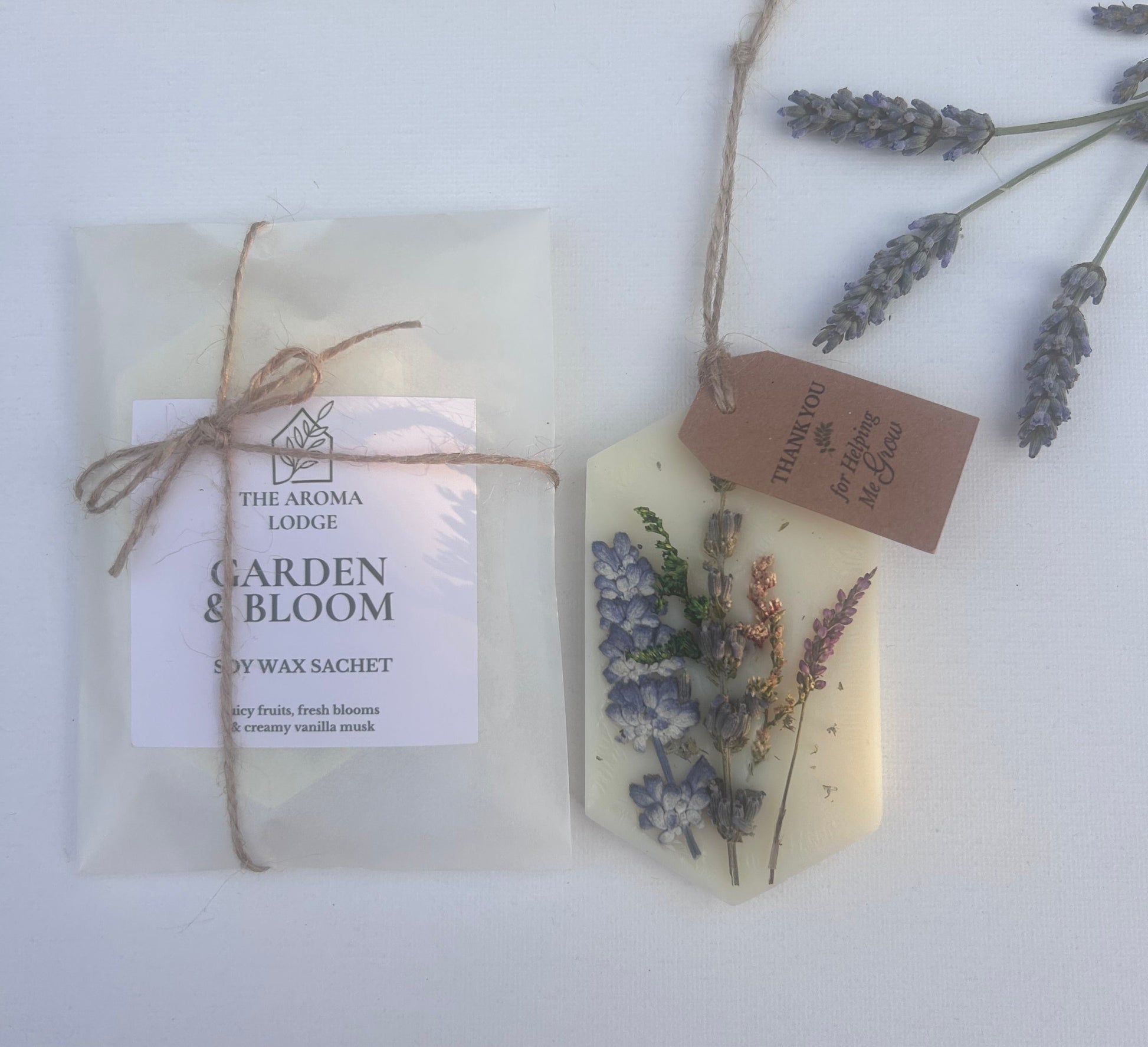 Two wax melt sachets with floral designs and packaging on a white surface.