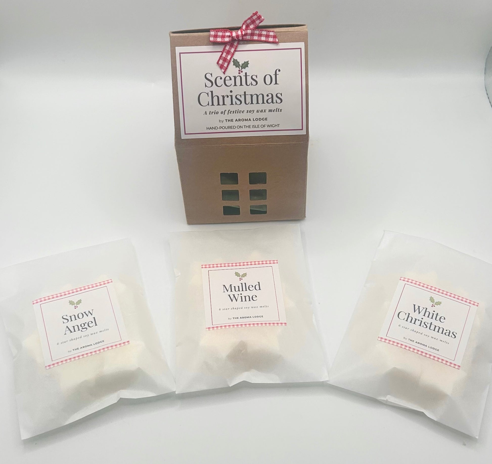 Packaged scented products with labels 'Snow Angel', 'Mulled Wine', and 'White Christmas' on a white background.