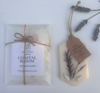 Two wax melt sachets with labels and lavender on a white surface