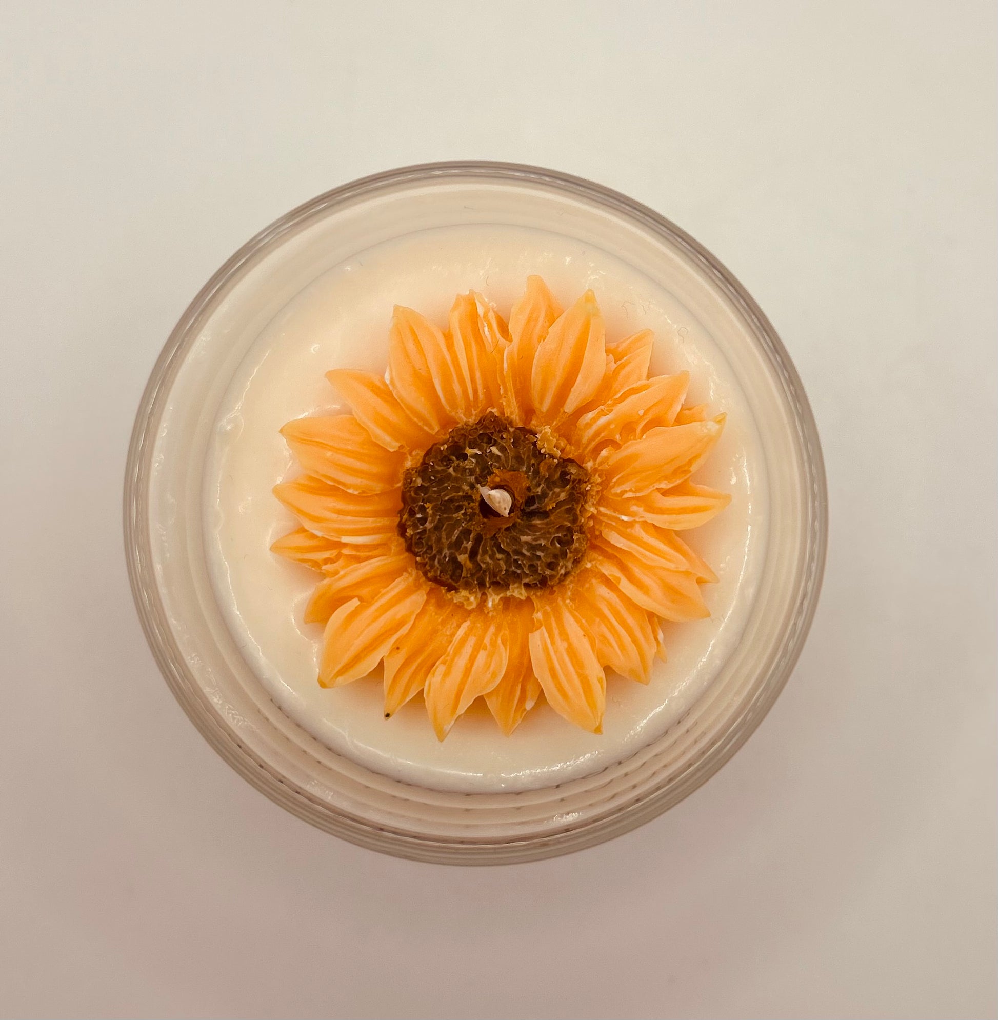 Candle with a sunflower design on a white background